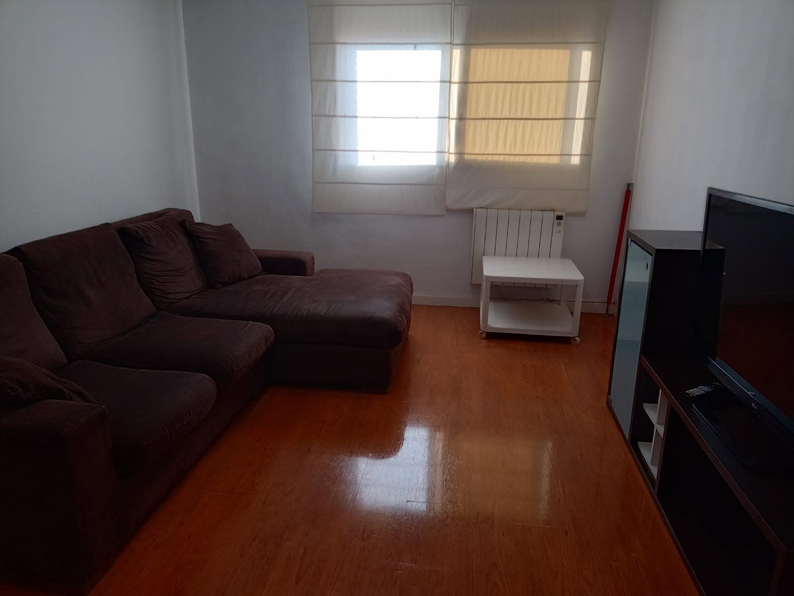 Salón con sofá y suelo de madera brillante recién limpiado